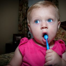 Bebé limpiándose los dientes con cepillo azul